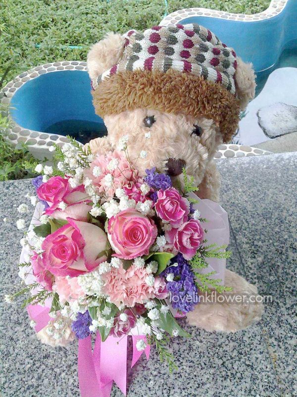 ช่อดอกกุหลาบสีชมพู และตุ๊กตาน่ารัก